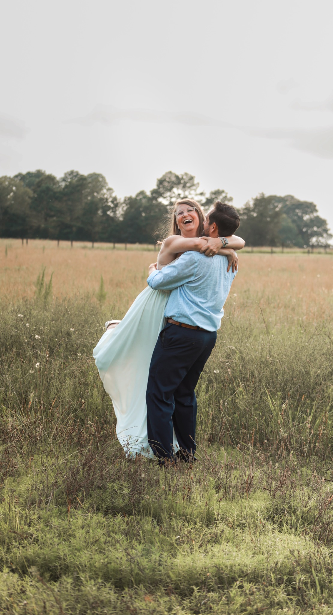 Couple embracing in a grassy meadow
